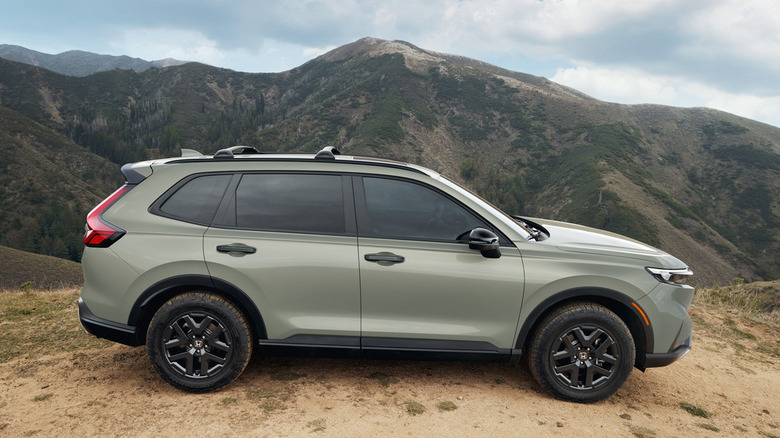 A green 2026 Honda CR-V parked in the dirt with mountains in the background