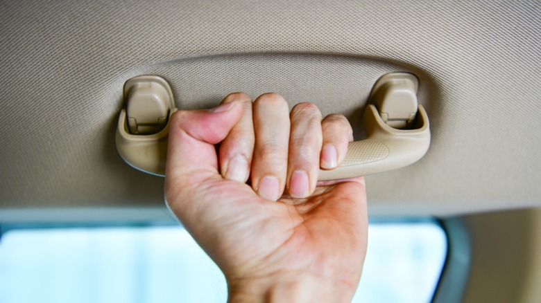 hand gripping car grab handle