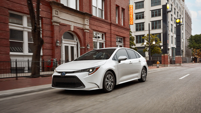 A white 2022 Toyota Corolla Hybrid driving through a town