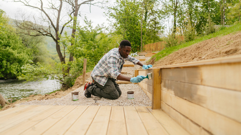 A person painting a wooden wall