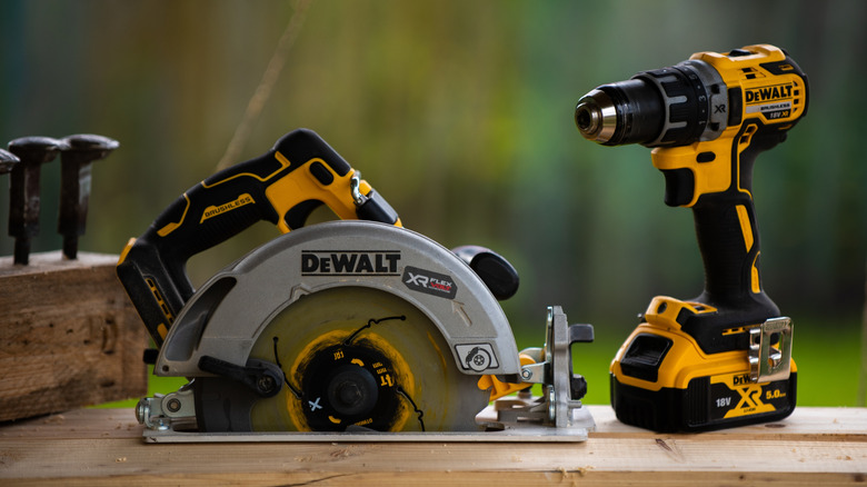 A DeWalt circular saw and drill/driver on a wooden work table