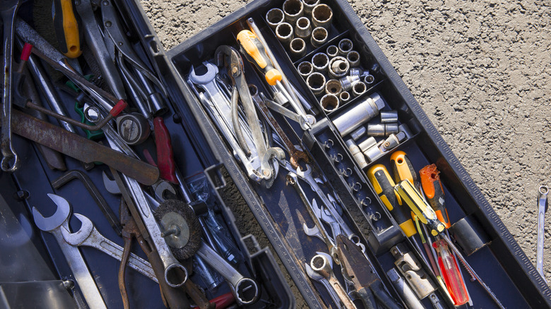Close-up of an opened tool kit on a driveway