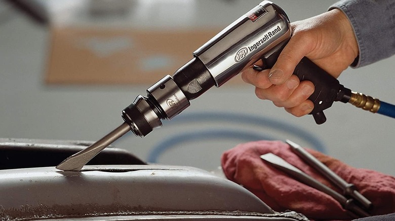 Hammering an automotive part with Ingersoll Rand air hammer.
