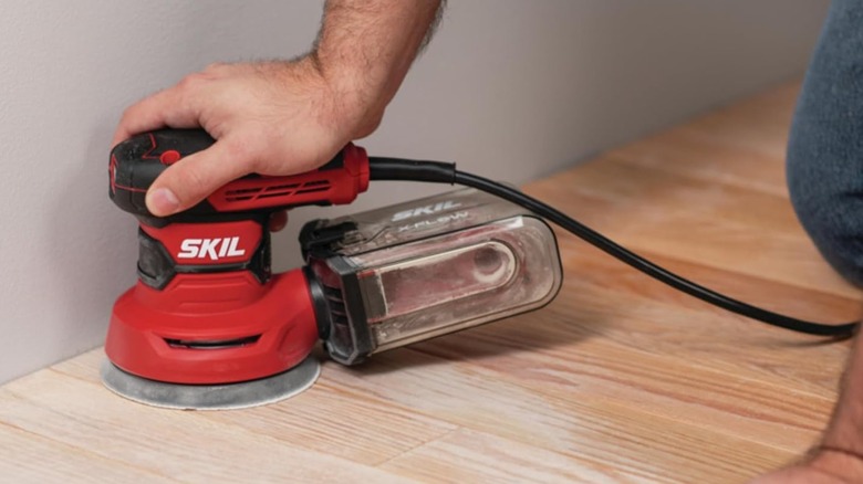 Sanding with a Skil random orbit sander.