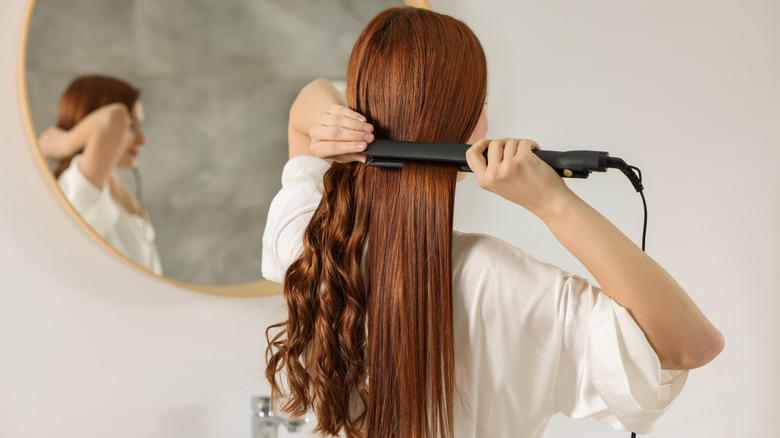 woman straightening hair