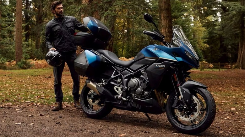 A Triumph rider accessing the top box of the 2026 Tiger Sport 800 Tour.