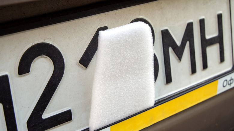 Part of a car's license plate covered.