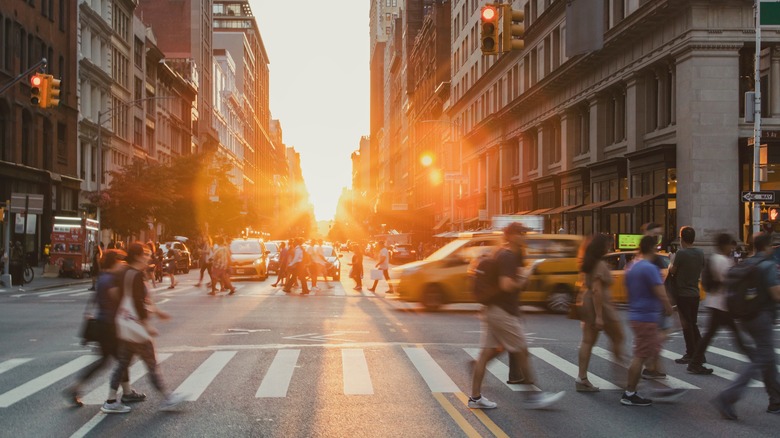 Pedestrians crossing the street at a busy intersection in New York City