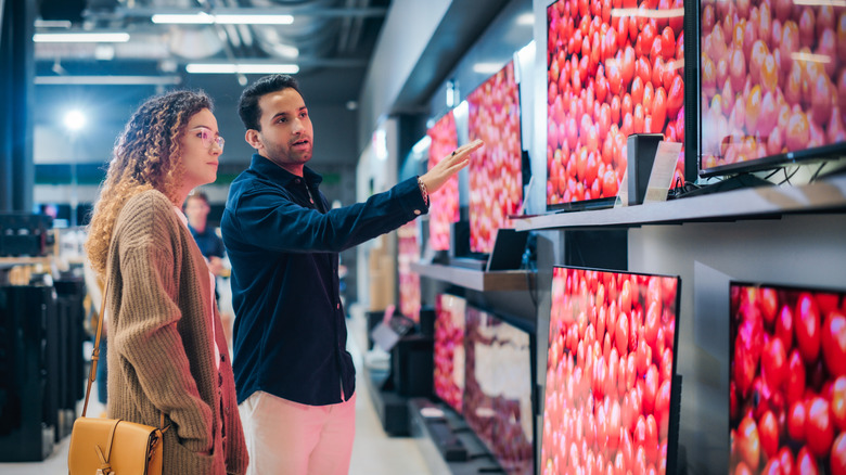 woman and man looking at a TV in a store