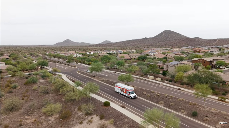 Overhead view of  U-Haul Easy Mover "EM" Peterbilt 36-foot moving truck rolling through a desert neighborhood