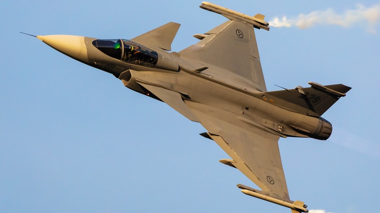 A Swedish Gripen flying against a blue sky.