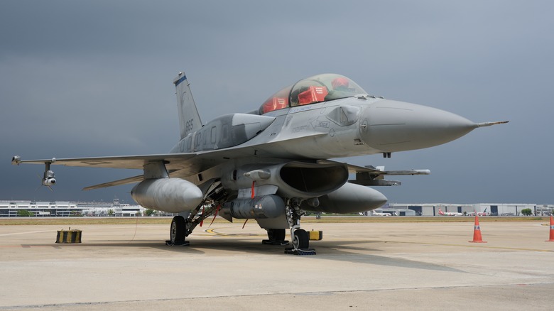 An F-16 parked on a landing strip.