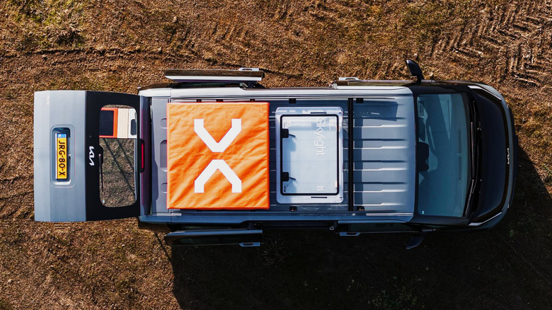 Overhead view of Vantrack PV5/LightCamp on dirt, showing skylight and rooftop tent