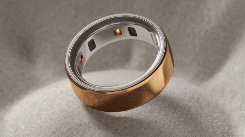 Gold Oura ring on a grey fabric background