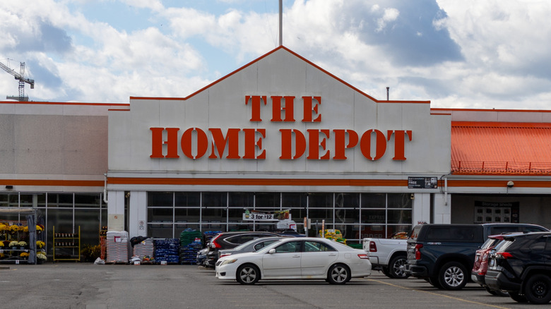 The facade of a Home Depot store, a large parking lot in front