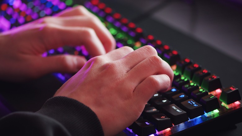 hands typing on RGB keyboard