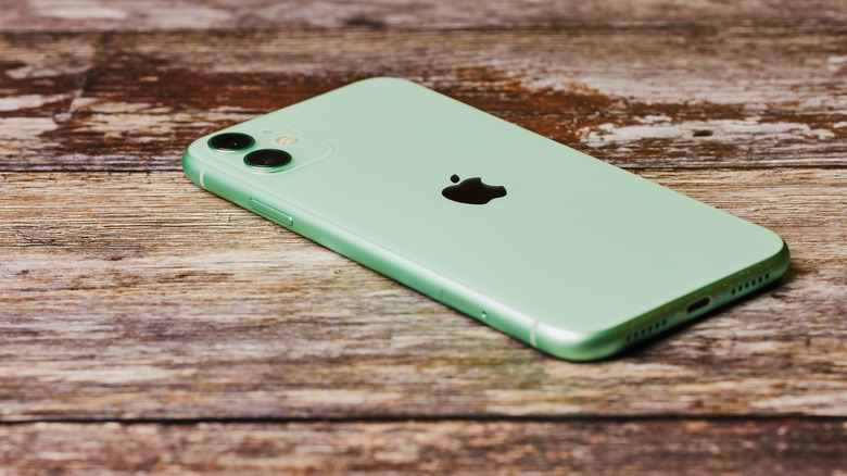 An iPhone 11 on a wooden surface