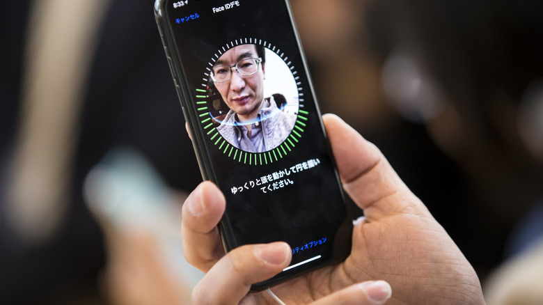 man uses iphone face id