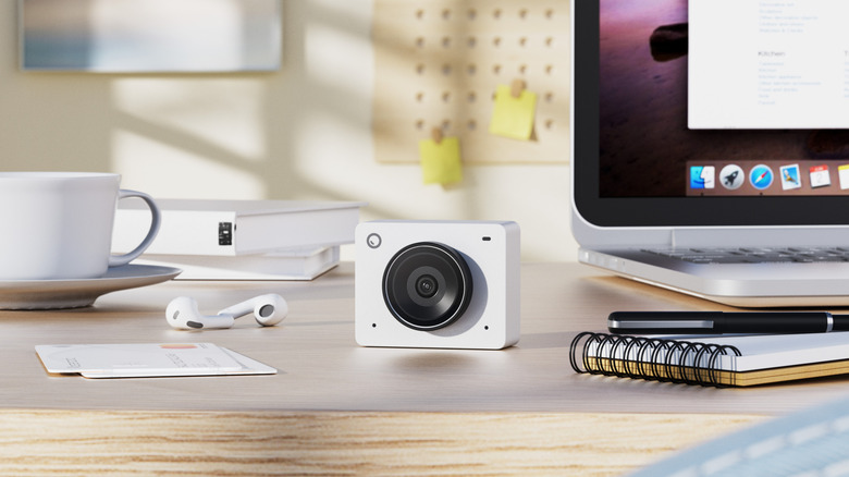 white OBSBOT Meet 2 webcam on a table with desk supplies