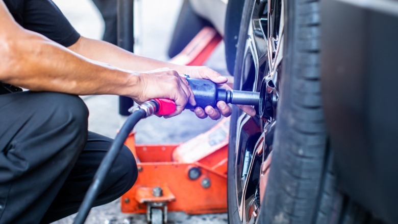 mechanic using pneumatic impact wrench