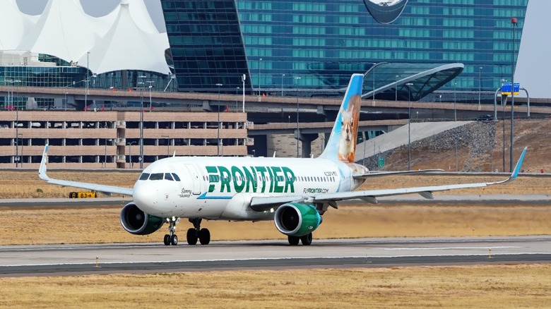 a Frontier Airbus A320 jet sitting on a runway