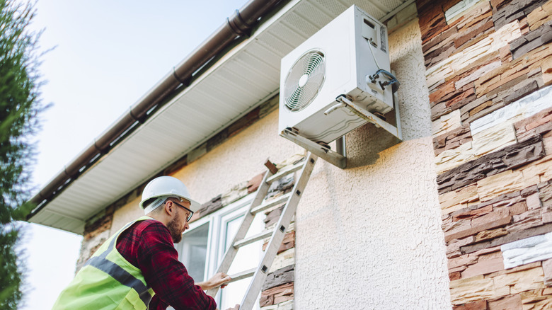 Professional working on home heat pump
