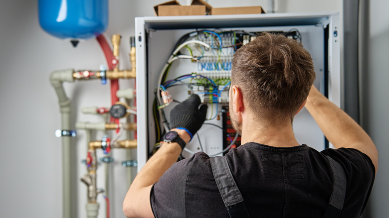 Professional installing heat pump system in home