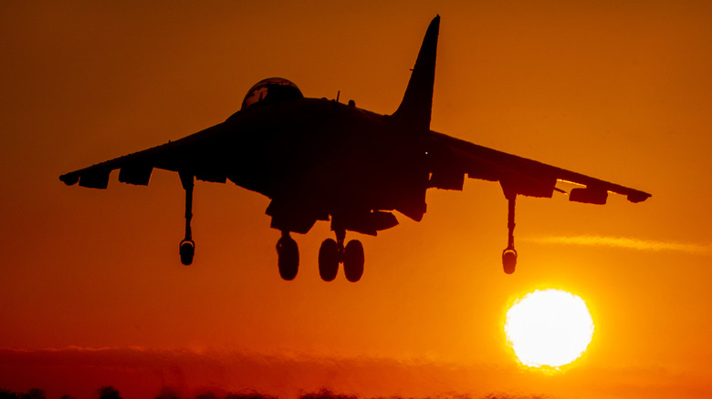 AV-8B II Harrier Jump Jet silhouette in the sky against sunset