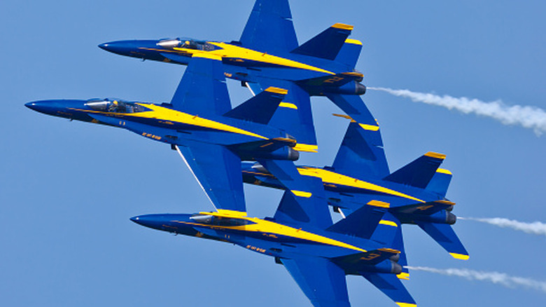 Four U.S. Navy Blue Angels F/A-18 Super Hornets in formation in a cloudless blue sky