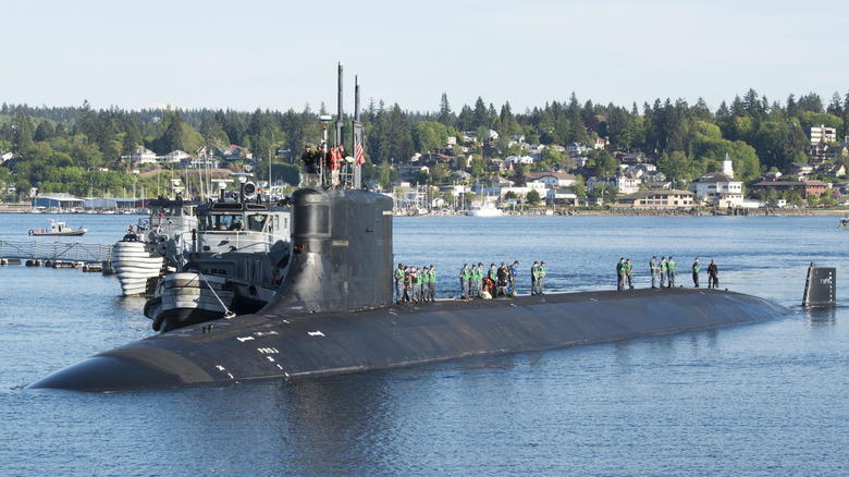 USS Connecticut on the surface of the water, with crew standing on top.