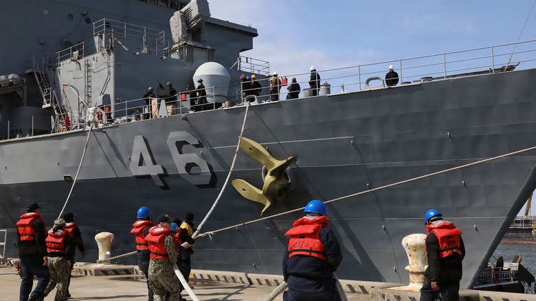 Naval dock workers preparing to untie the USS Tortuga from its dock
