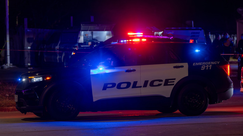 Police car with lights on at side of road