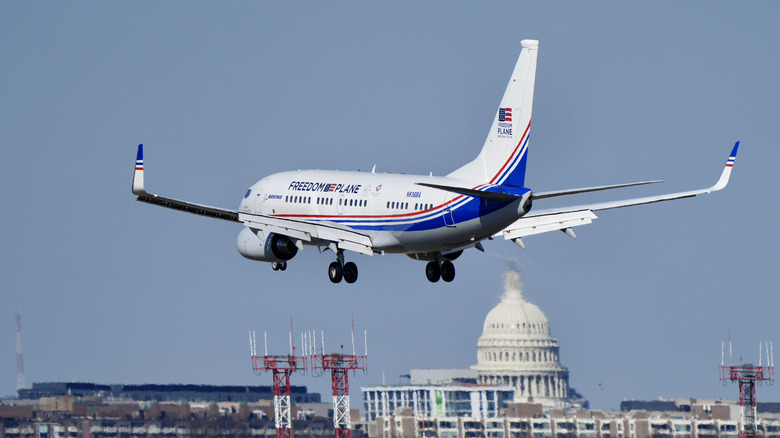 Rear view of Freedom Plane landing with US capitol in background.