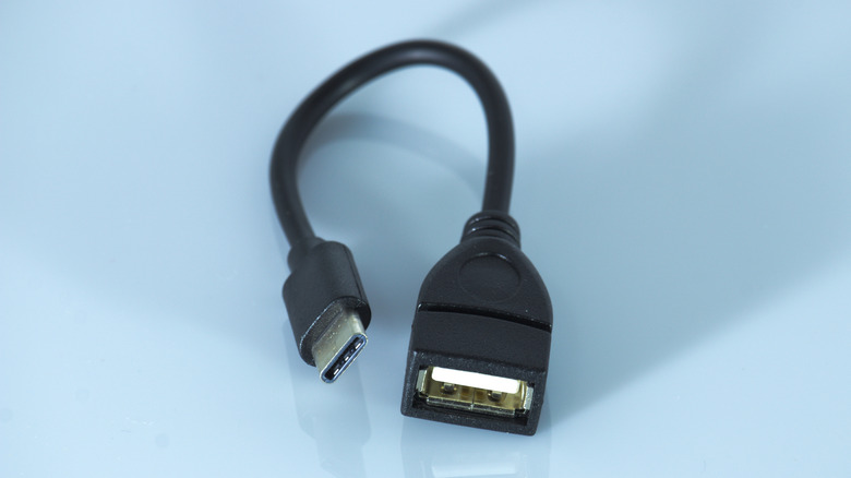 A black USB OTG cable on a blue surface
