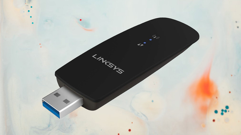 Linksys USB wireless network adapter on a paint splattered background