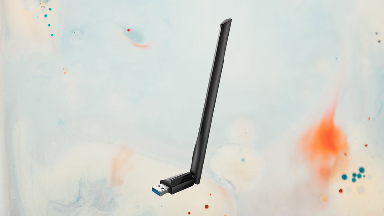 TP-Link USB wireless network adapter on a paint splattered background