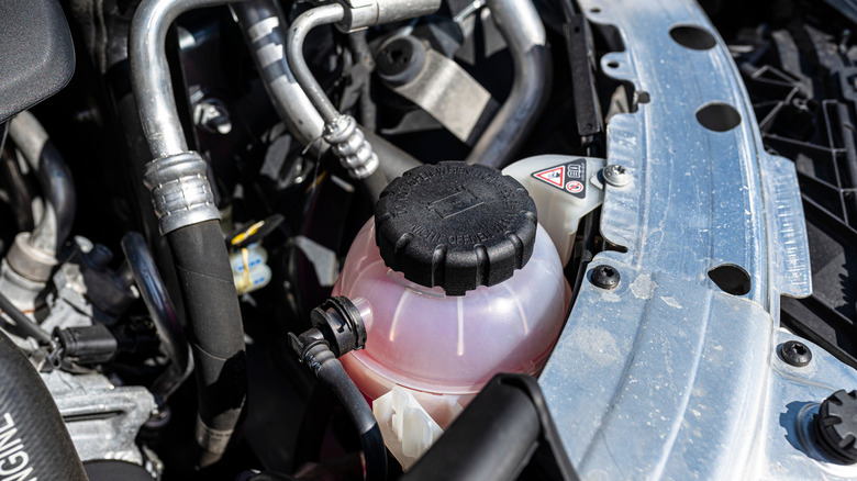 Closeup shot of car engine with pink diesel coolant in coolant reservoir