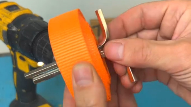 Person removing hex keys from wound ratchet strap