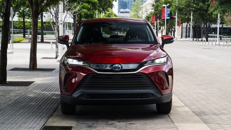 Front-end view of a red 2021 Toyota Venza Limited parked in an urban setting.
