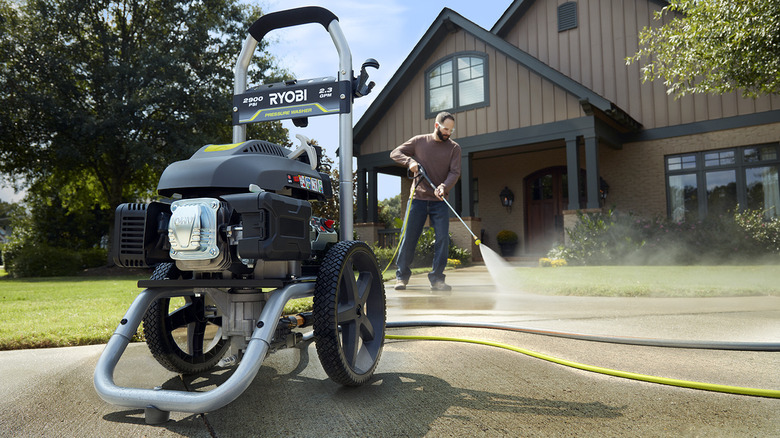 person using 35-foot hose with Ryobi pressure washer in foreground