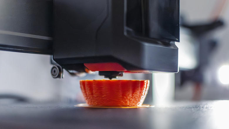 An object mid-print on a 3D-printer bed