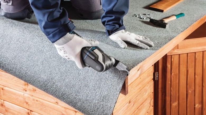 man using Bosch multi tool with carpet