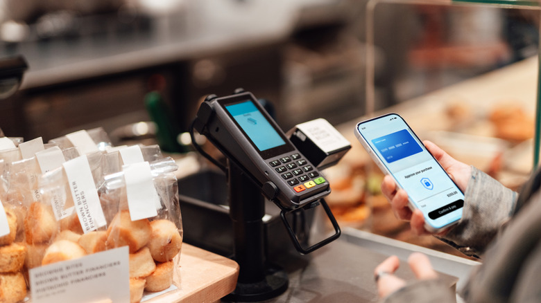 A woman makes a purchase using her mobile wallet.