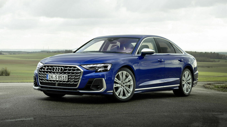Blue Audi S8 parked in front of fields