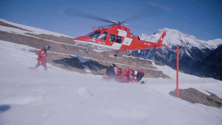 Rega Da Vinci helicopter landing on a snowy mountain