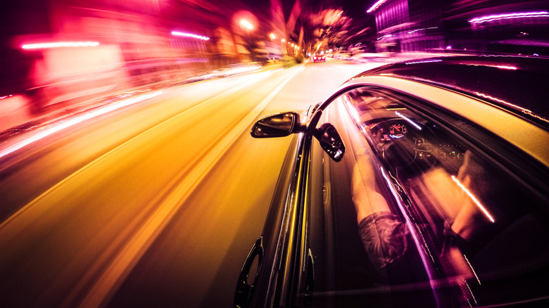 A car going fast in the city at night