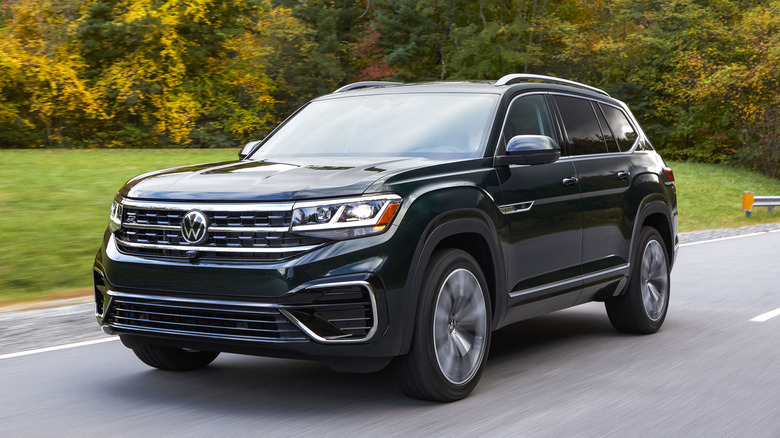 2022 VW Atlas driving on a road with trees and lush green grass in the background