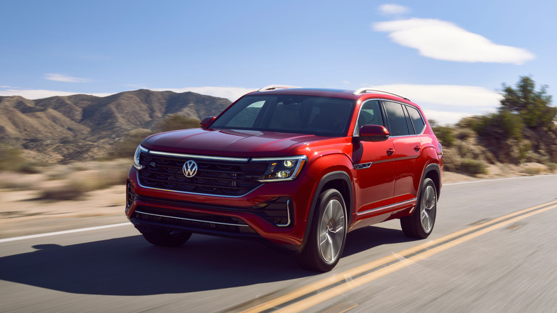 A red 2024 Volkswagen Atlas on a road.