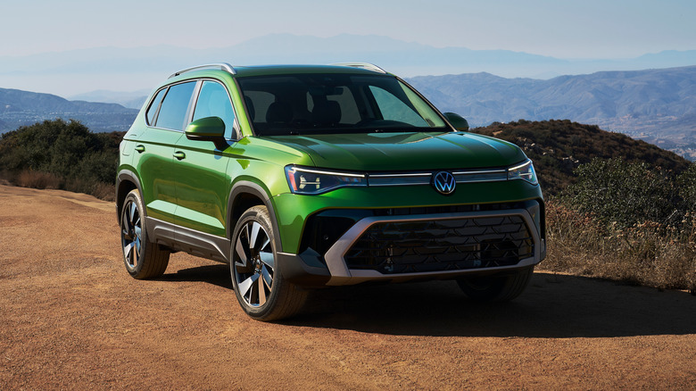 A 2025 Volkswagen Taos on a sandy trail, front 3/4 view, green exterior