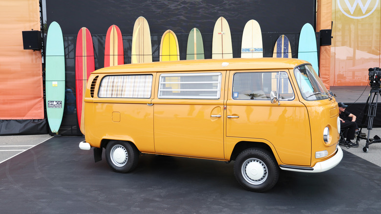 Yellow VW beetle bus with surfboards